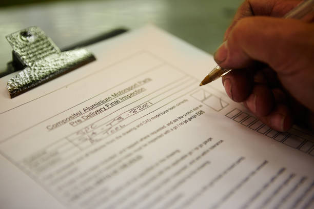 Close-up of a hand of an engineer filling a pre delivery inspection form Close-up of a hand of an engineer filling a pre delivery inspection form