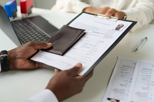 Close-up of man giving documents to specialist to get visa Close-up of man giving documents to specialist to get visa
